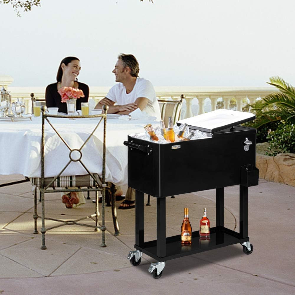 Black rolling cooler on a stand next to an outdoor dining table, lid open with bottles and ice and two bottles on the bottom