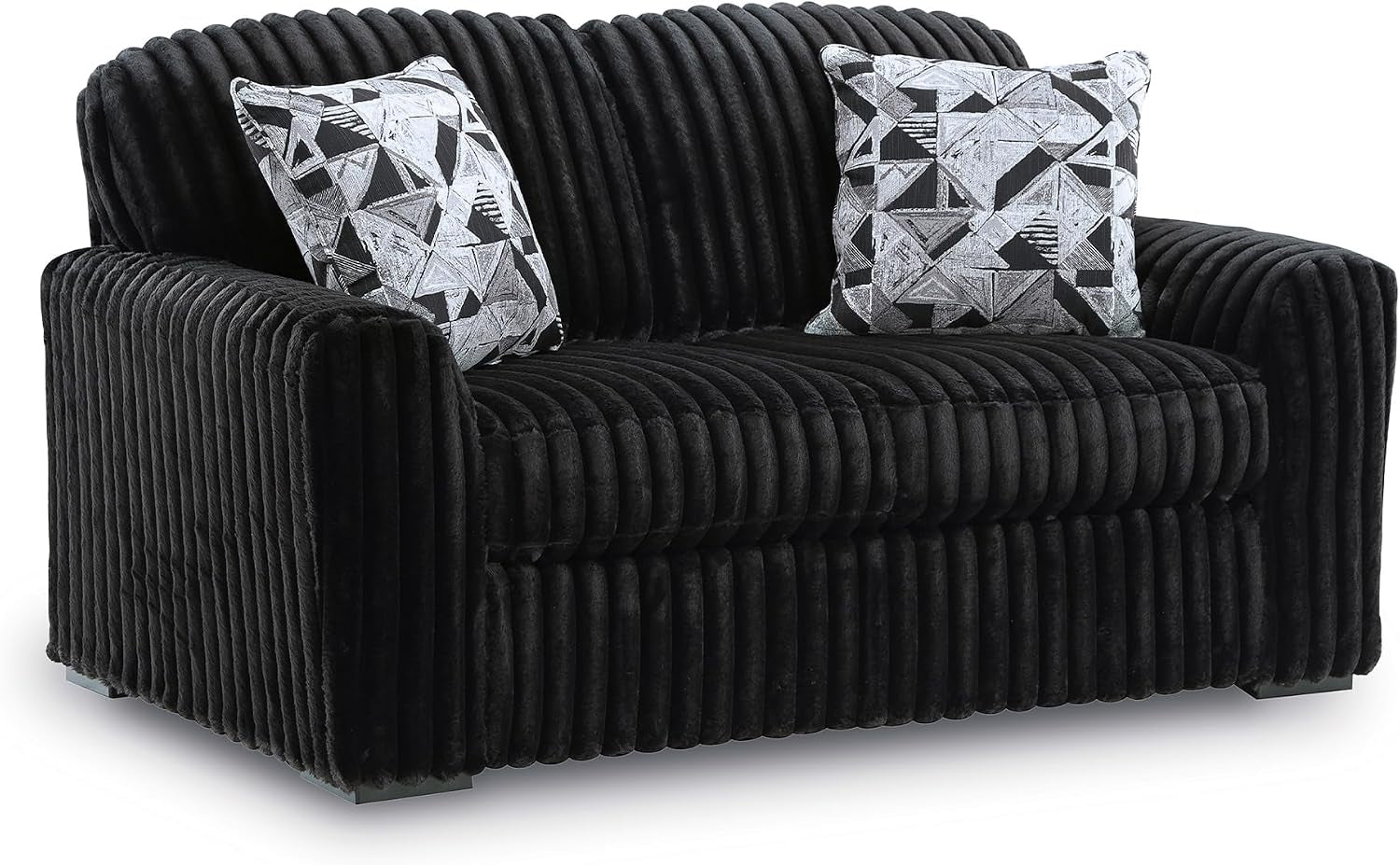Angled three-quarter view of a ribbed, dark chaise-style loveseat with two patterned throw pillows.
