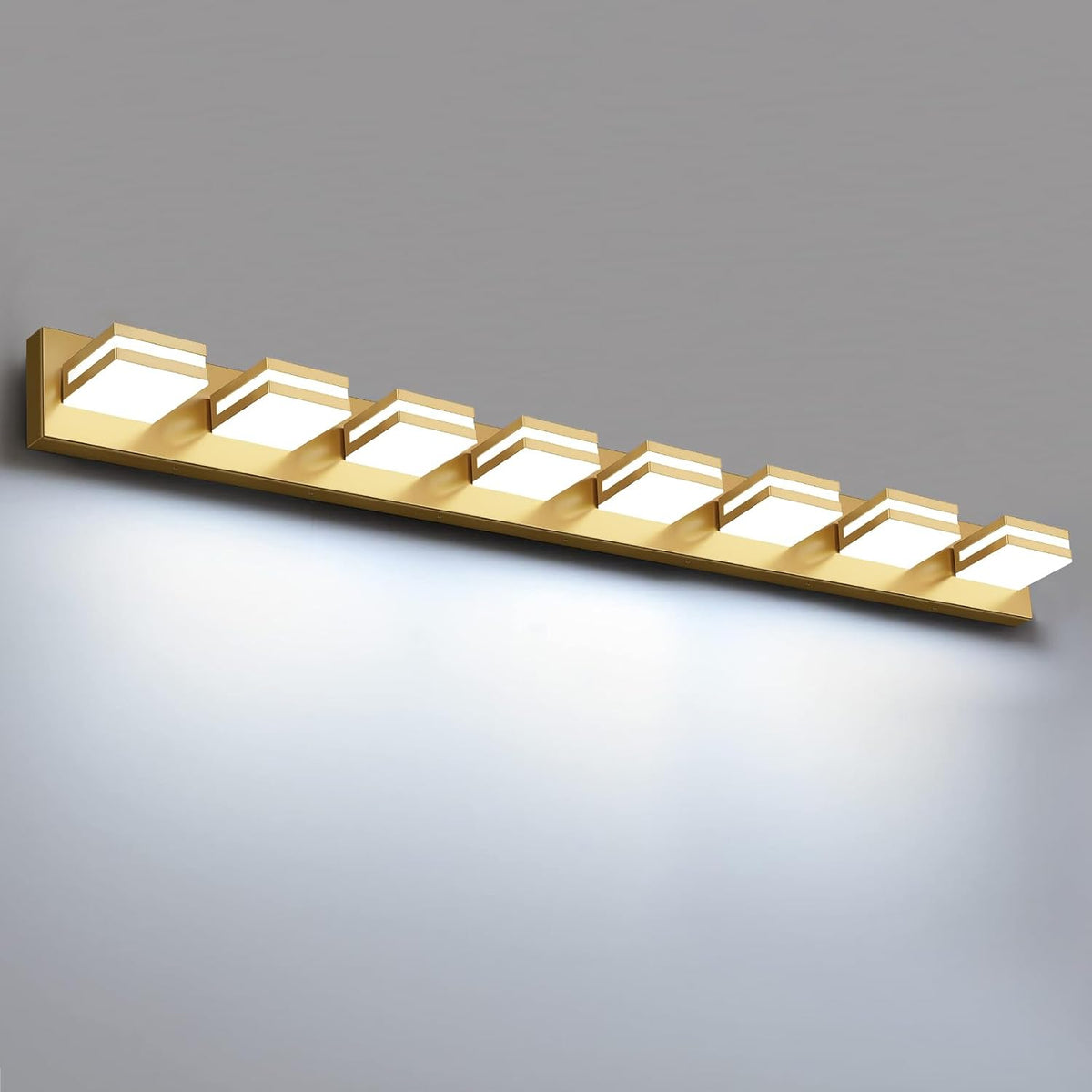 Wide angled view of a longer gold LED vanity fixture with eight illuminated square modules.