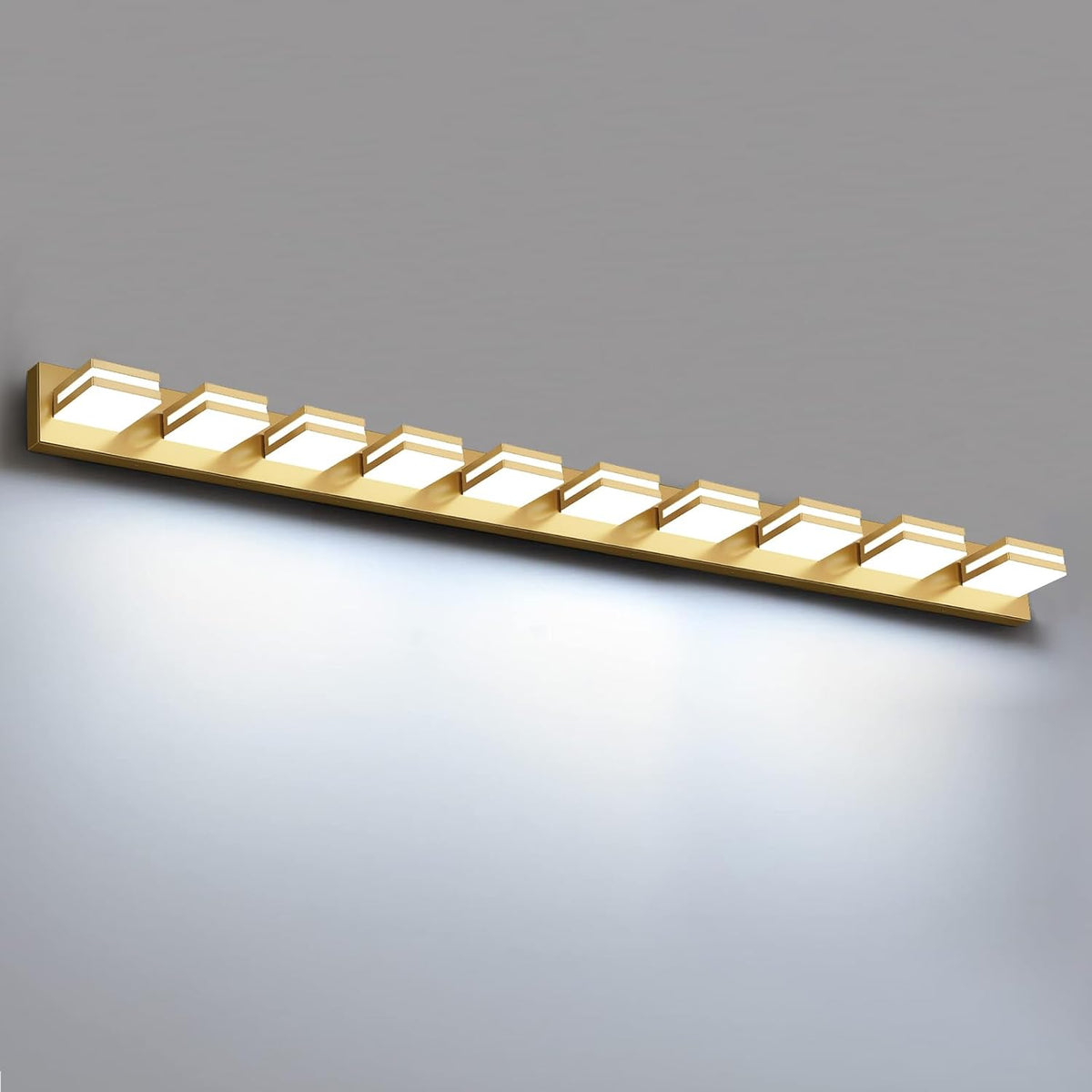 Long gold wall vanity light with ten illuminated square LED modules mounted on a single bar.