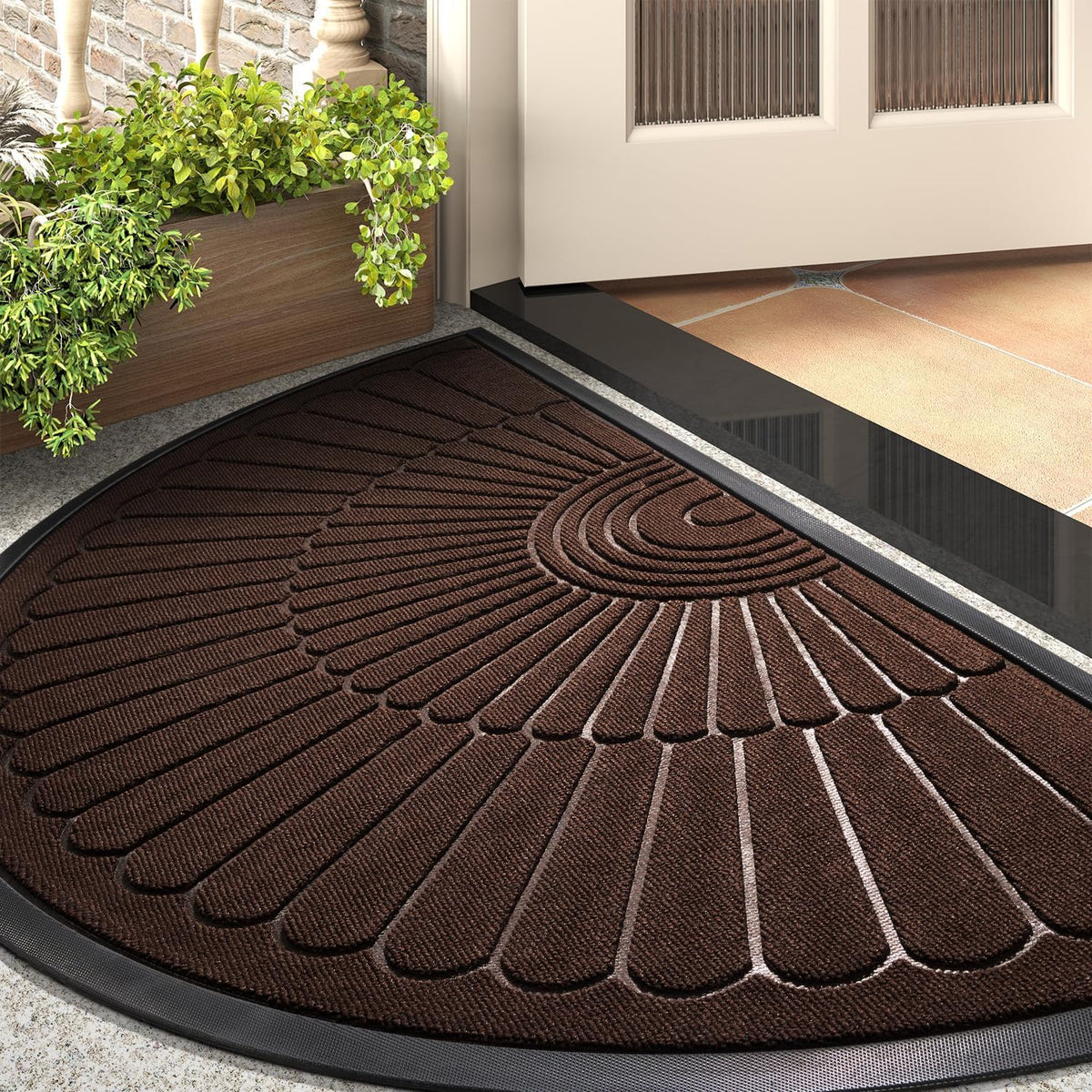 Angled close-up of a brown semicircular doormat at an open front door beside a wooden planter.