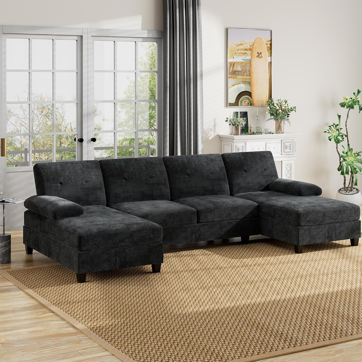 Dark charcoal U-shaped sectional with double chaise in a bright living room.