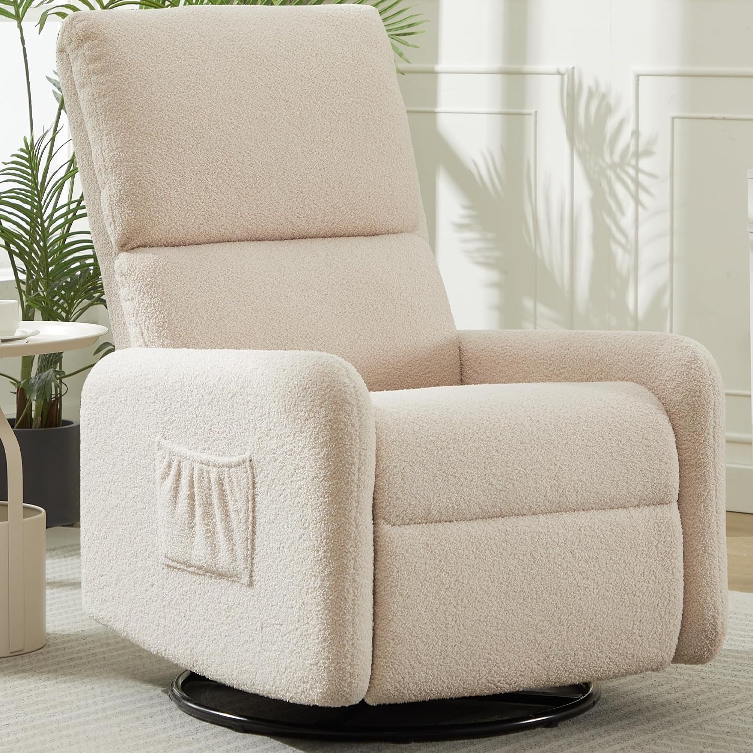 Close-up of a cream sherpa swivel rocker showing side storage pocket and black circular base