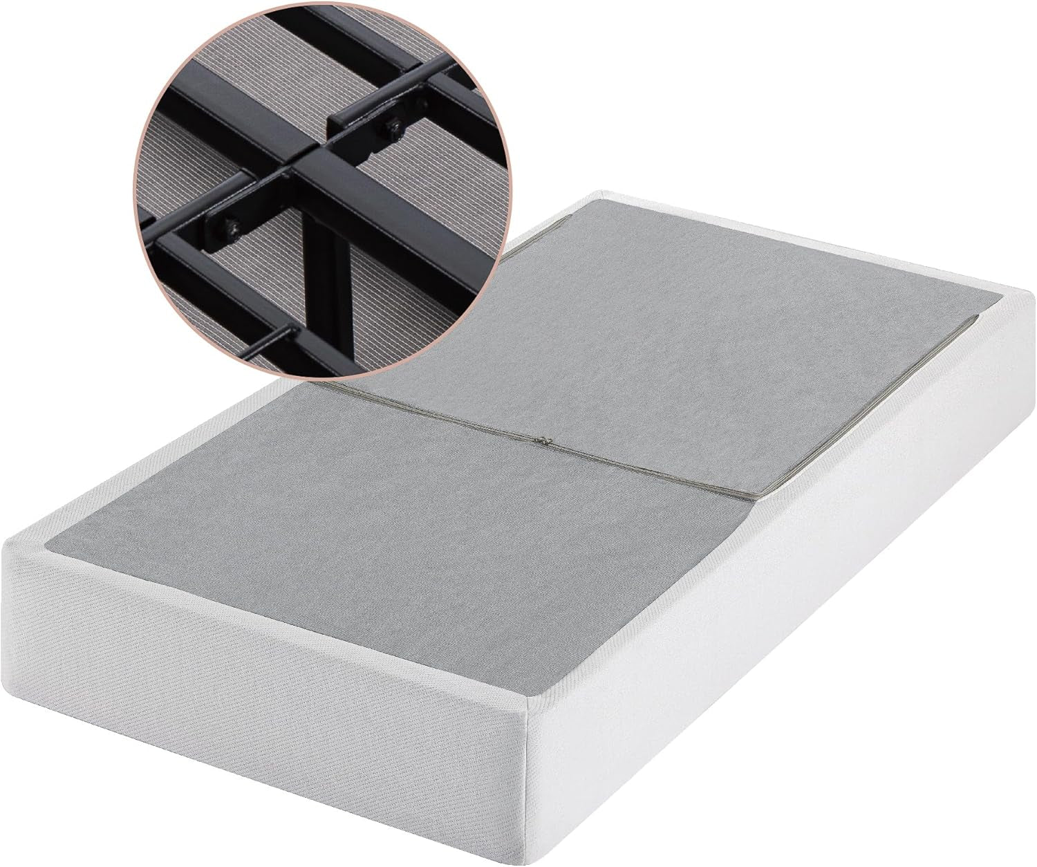 Angled view of a white fabric-covered box spring with gray top panels and a round inset showing black metal frame detail.