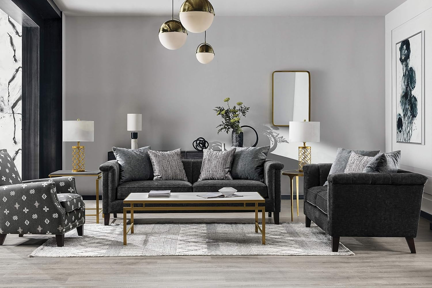 Deep grey velvet sofa styled in a living room with matching armchair, coffee table, and rug