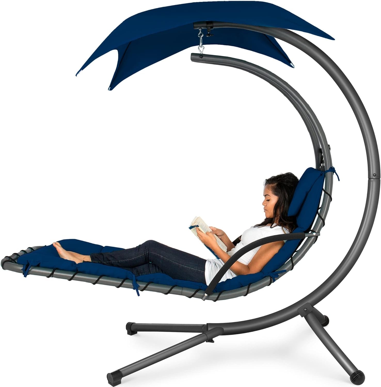 Curved hanging chaise with teal canopy and cushion, woman reclining and reading a book.