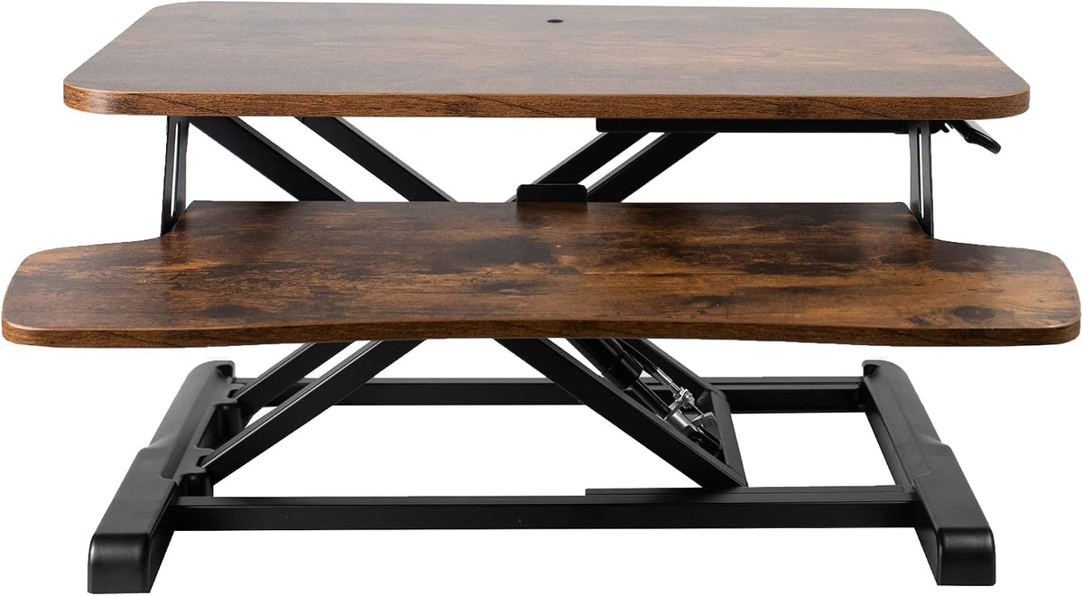Front view of a two-tier standing desk converter with dark wood tops and black metal X-frame