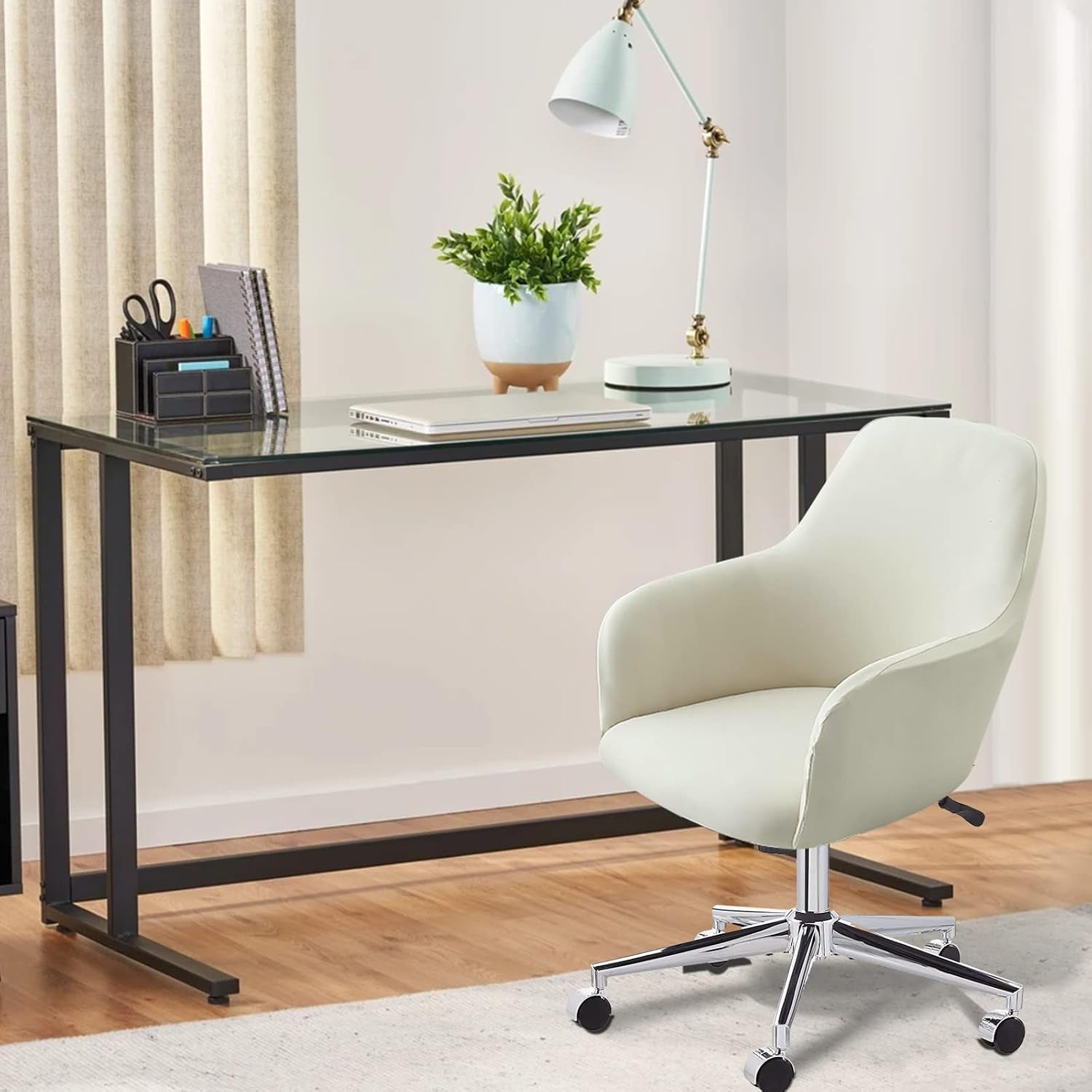 White slipcovered mid-back armchair positioned at a glass desk in a home office setting