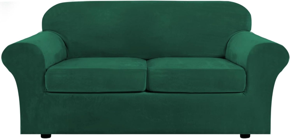 Front-facing two-seat sofa in deep forest green velvet showing curved arms and short black feet.