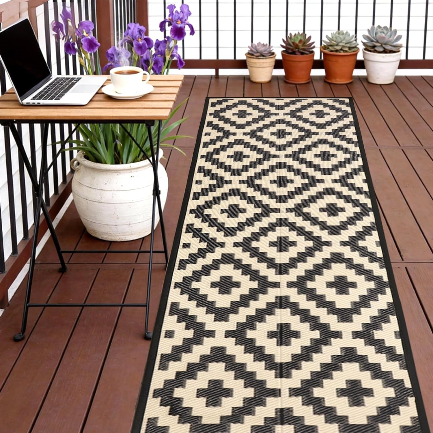 Narrow porch with a patterned runner rug beside a small table, potted plants in background.
