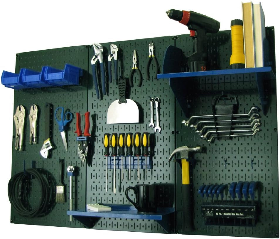 Dark green/black pegboard with tool bins, a drill, wrenches, a hammer and a small shelf installed.