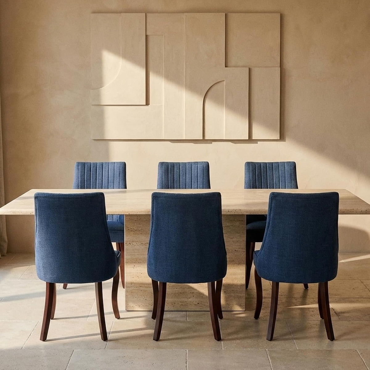 Dining table with six blue upholstered high-back chairs arranged around it in a sunlit room