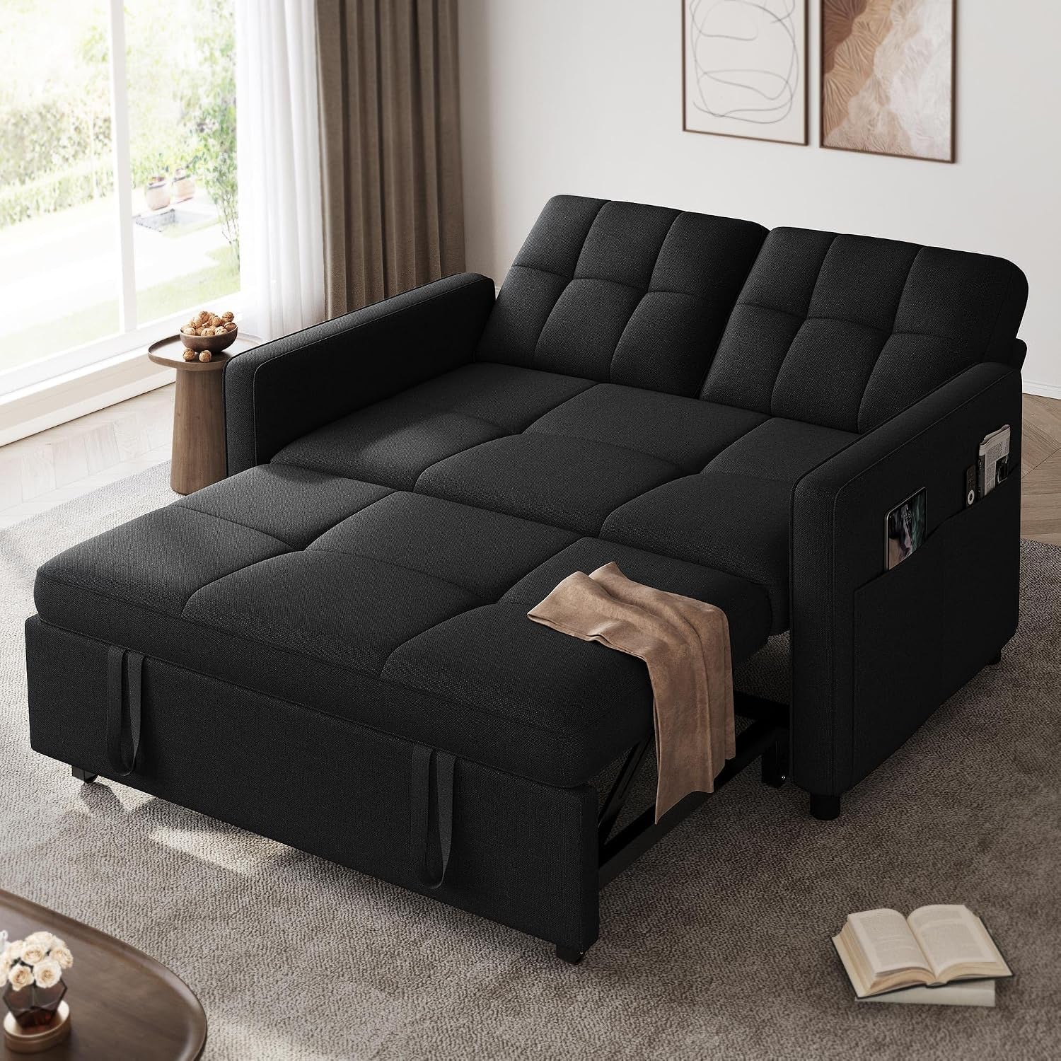 Dark charcoal futon opened flat into a bed with padded tufted surface and boxed armrests