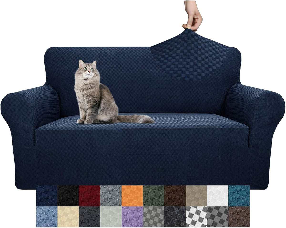 Hand stretching the navy slipcover fabric on a sofa back while a gray cat sits on the seat.