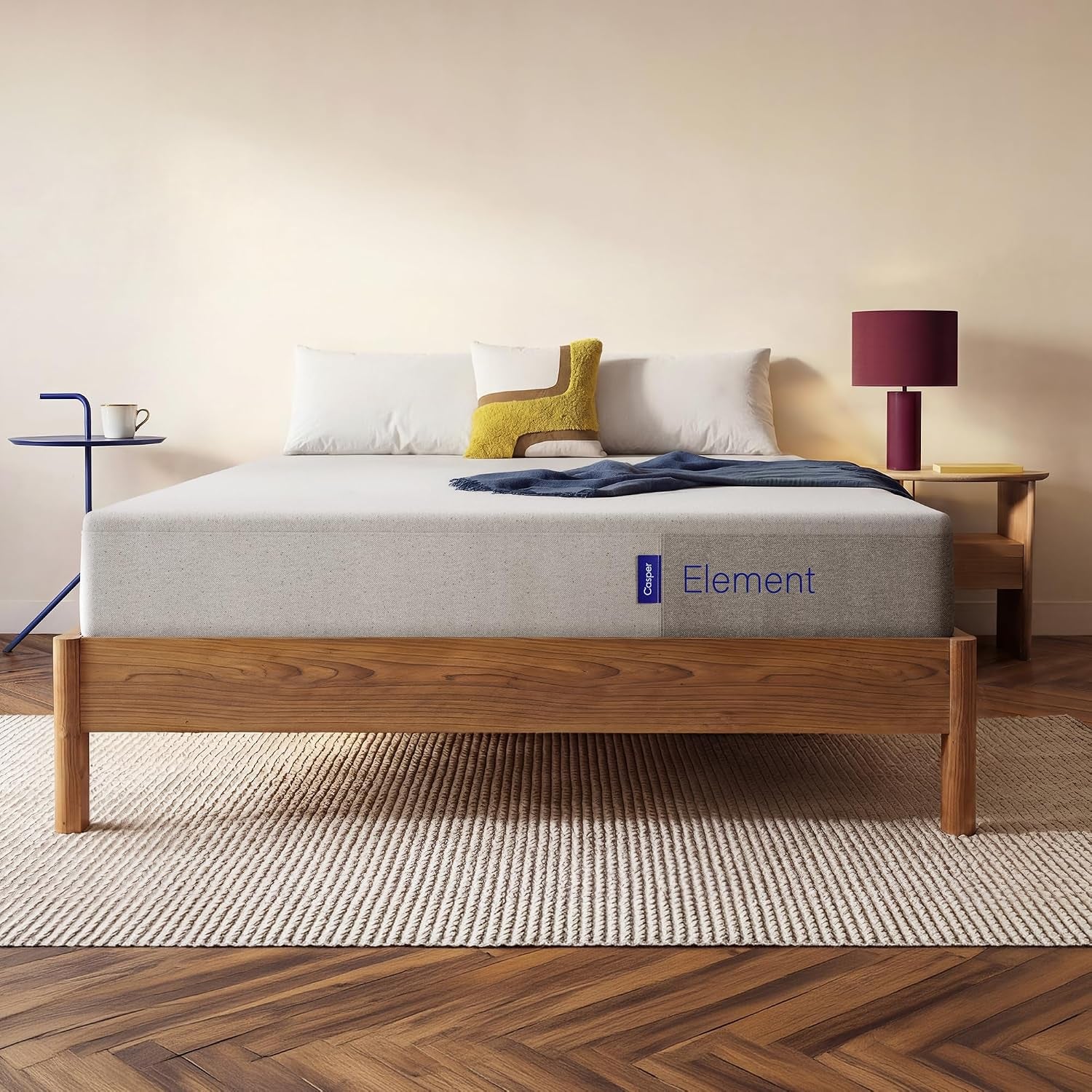 Light-gray 10-inch foam mattress on a wooden platform bed viewed from the foot of the bed.