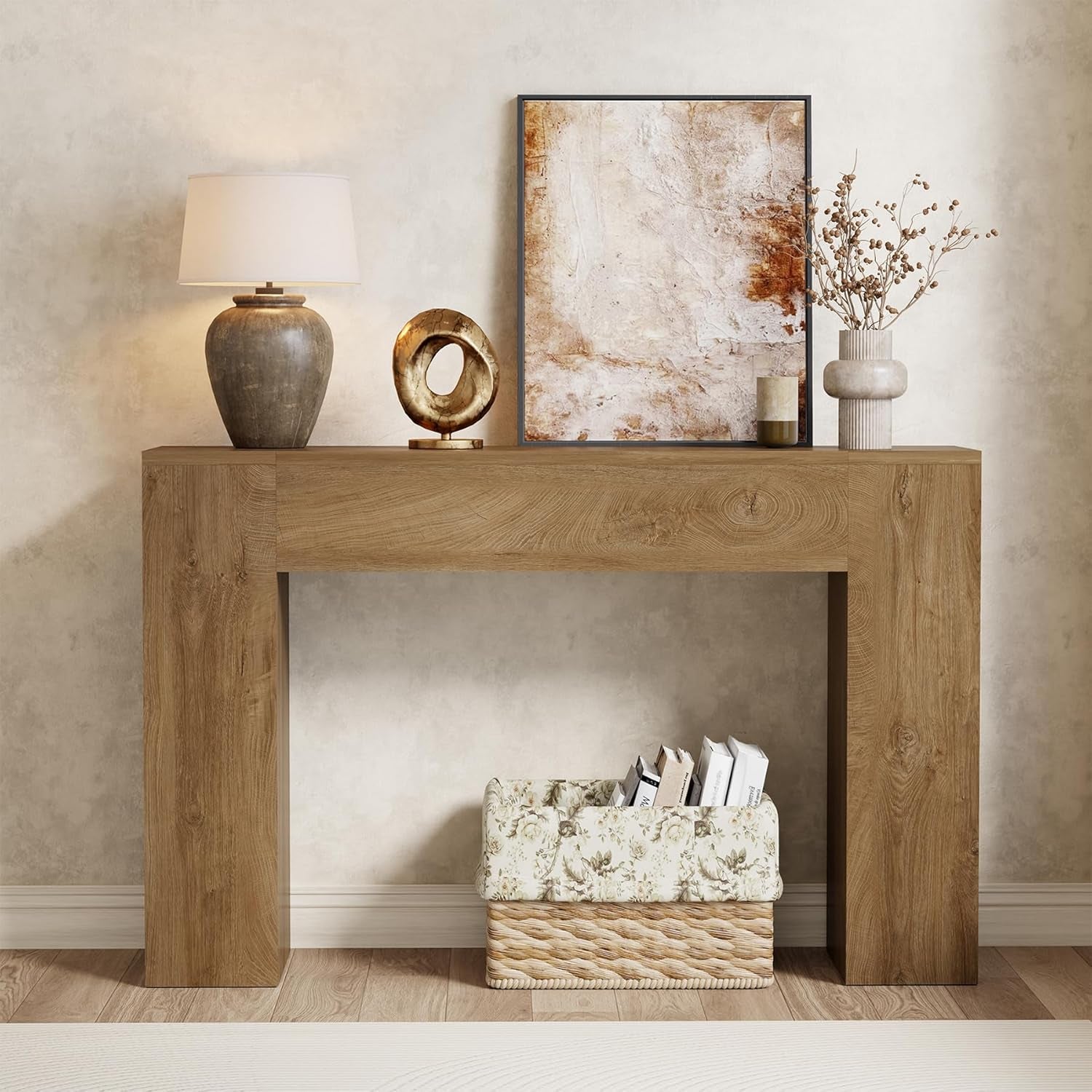Warm light oak brown console table front view with lamp, framed artwork and a wicker basket beneath
