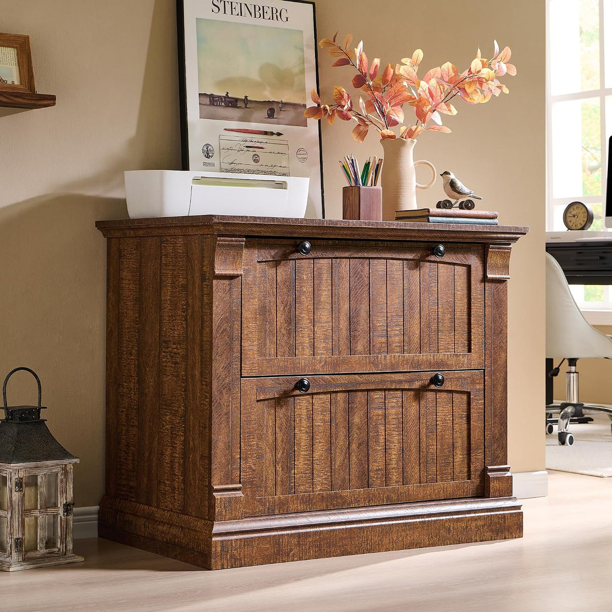 Dark brown two-drawer farmhouse file cabinet styled with decor and a vase on top near a desk.