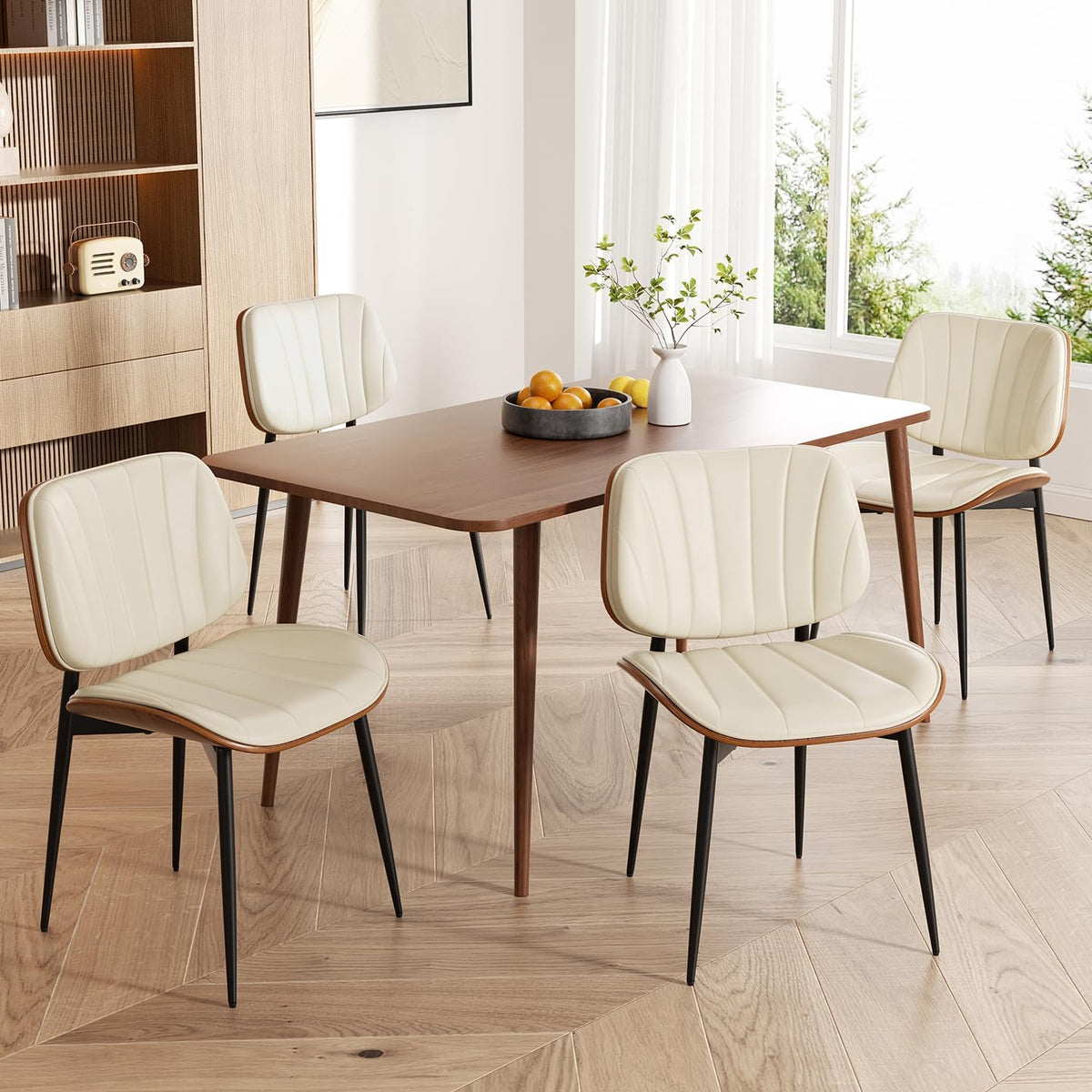 Wood table surrounded by cream faux-leather chairs with walnut back panels.