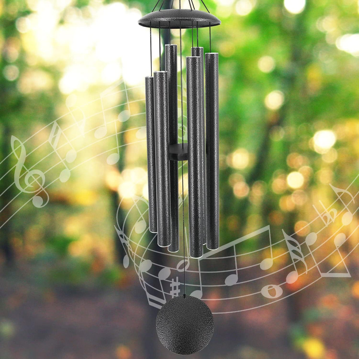 Close-up of black textured wind chime tubes and circular sail over blurred bokeh background.
