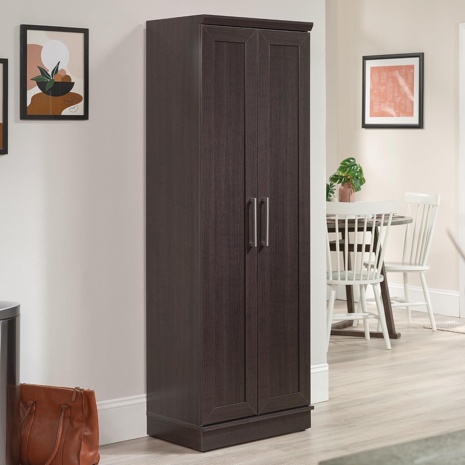 Dark brown tall storage cabinet in a dining area, angled front view showing full height and slim profile.