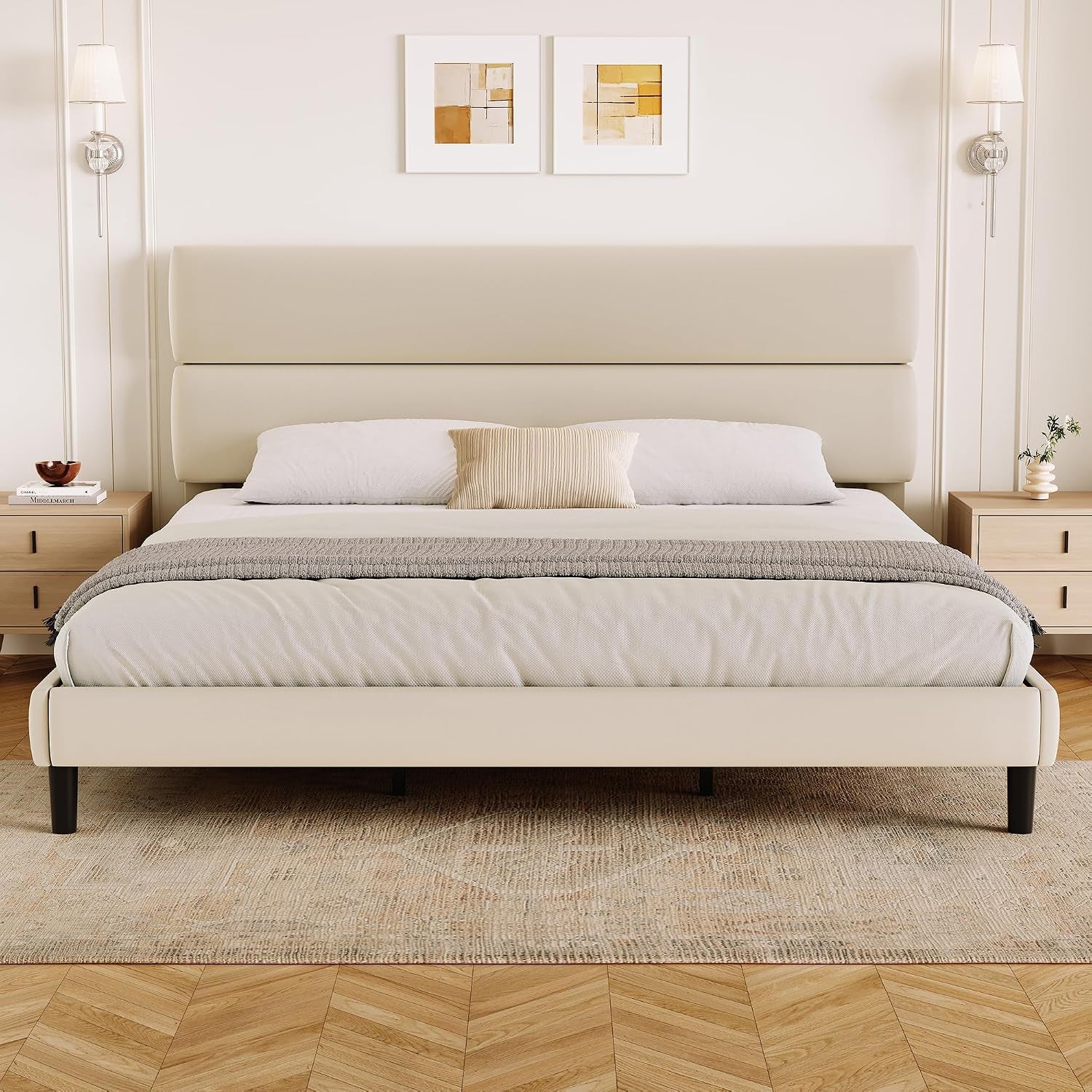 Symmetrical room view of a wide cream bed with two headboard panels and an upholstered footboard.