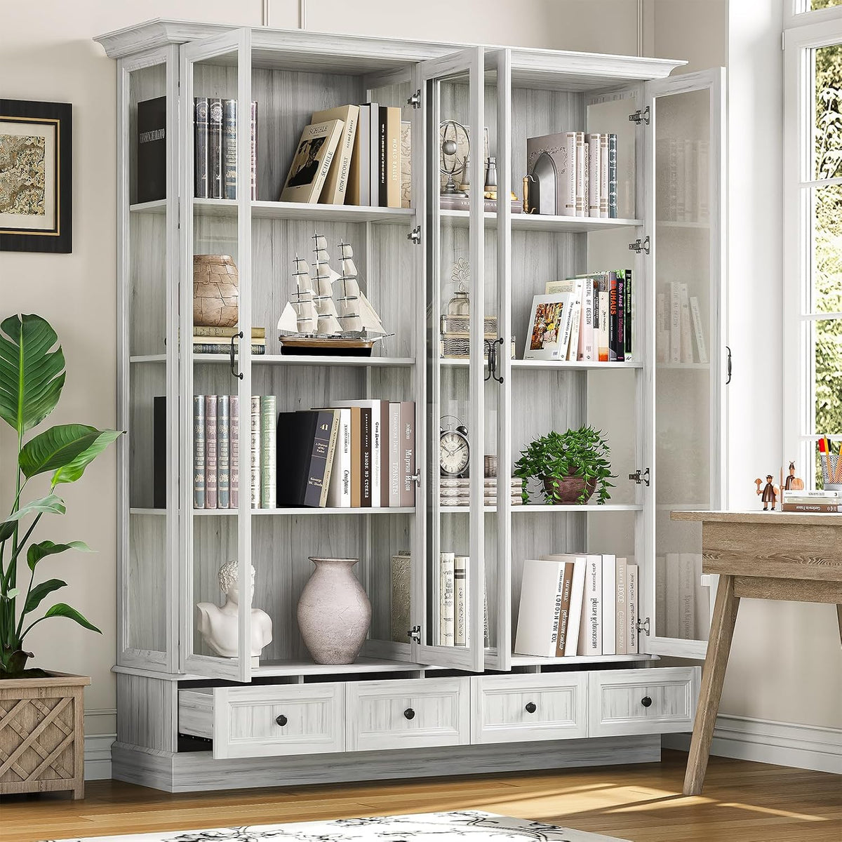 Angled close view of glass doors open on a light grey tall storage cabinet with books and decor