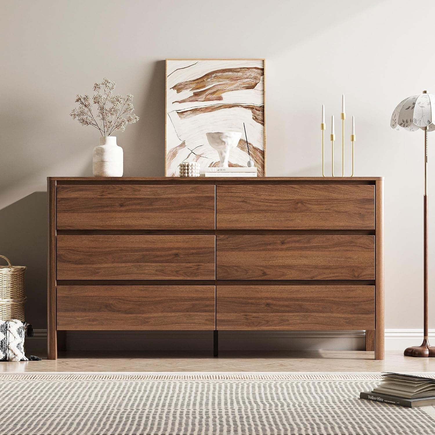 Head-on view of the six-drawer front with a centered abstract painting and stacked decor, showing the black center support
