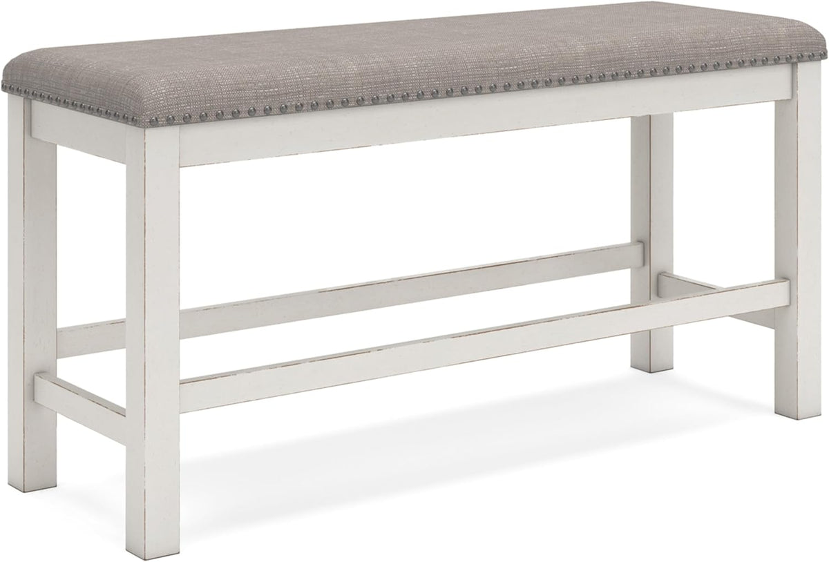 Light gray upholstered counter-height bench with antiqued white wood frame, angled front-right view
