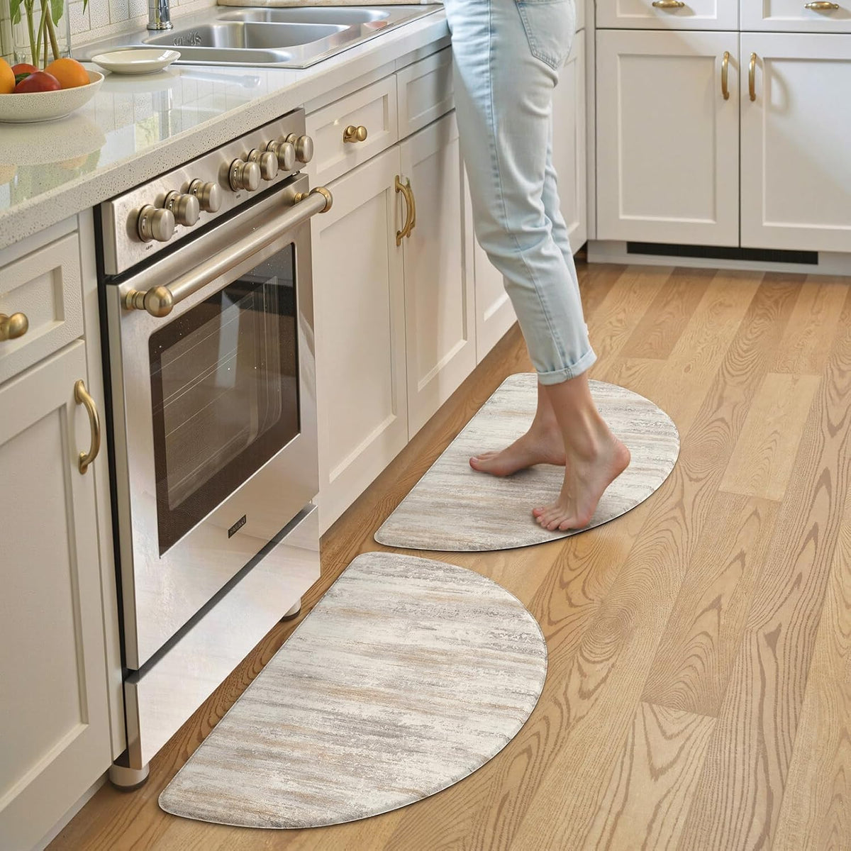 Two crescent-shaped mats by a stove with bare feet standing on the nearer mat.