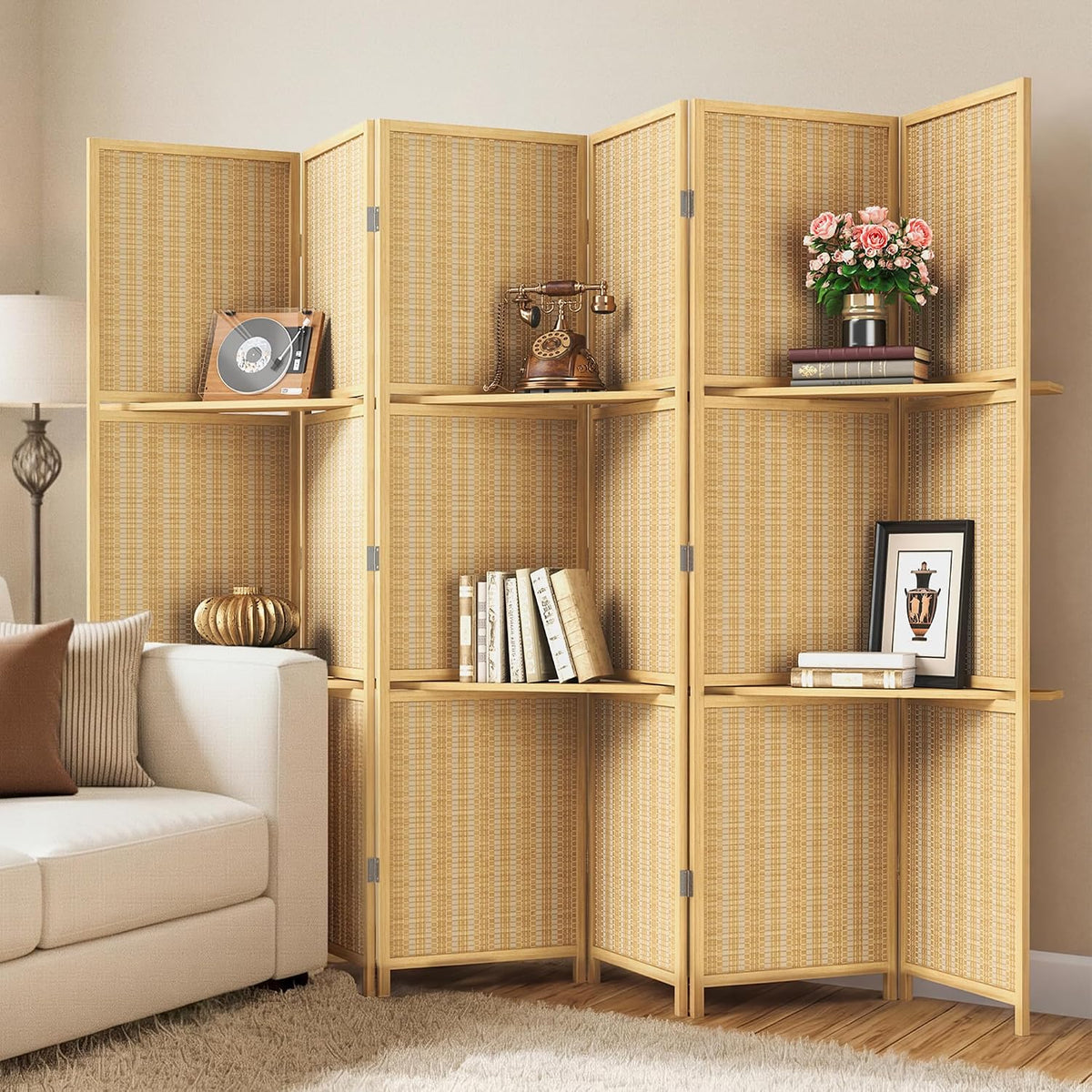 Light natural bamboo divider used as corner shelving holding books, vase and vintage phone