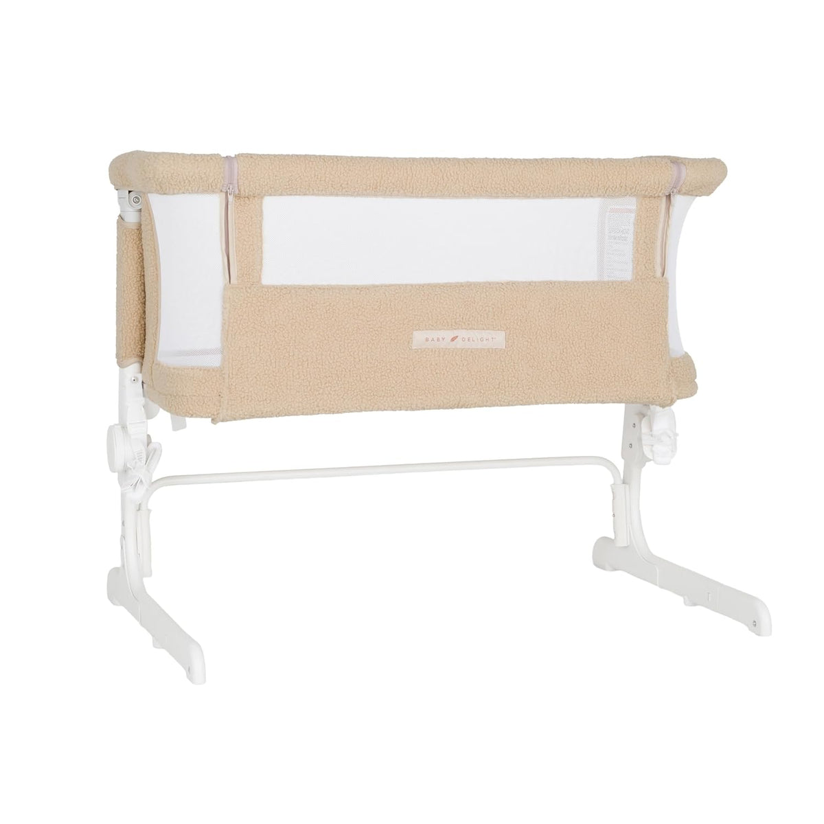 Beige sherpa-covered bedside bassinet on white metal legs with mesh side panel