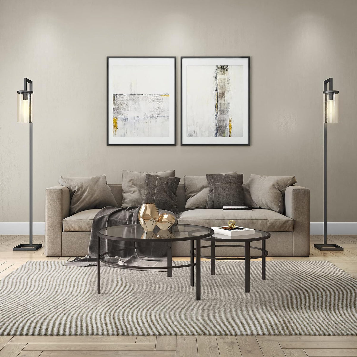 Living room scene with round glass nesting coffee tables in blackened bronze on a patterned rug in front of a sofa