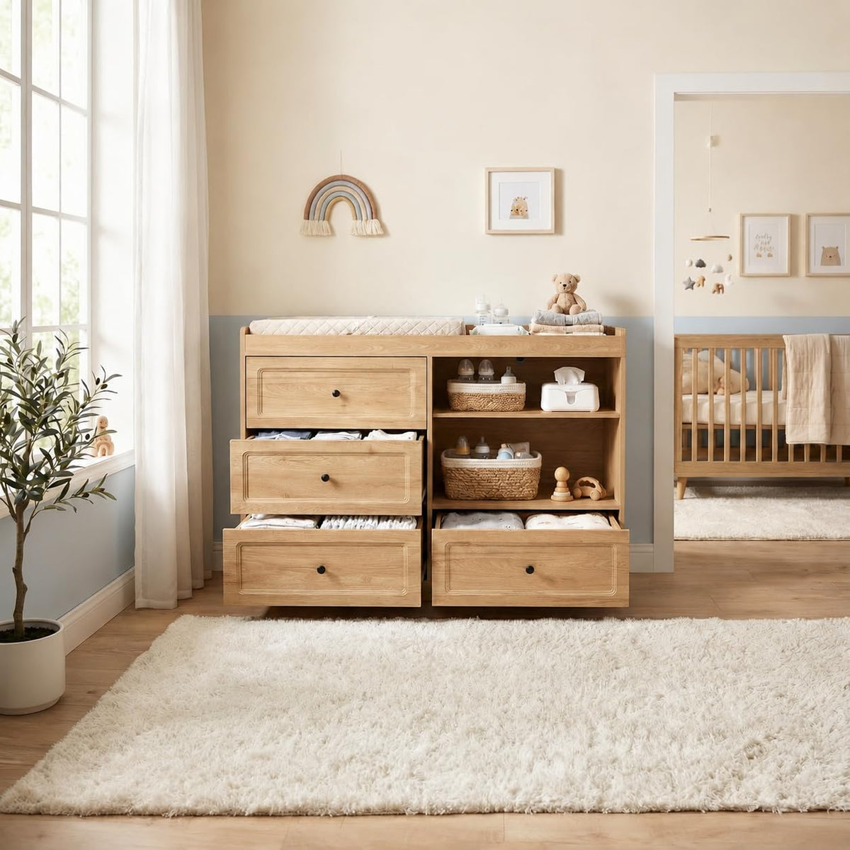 Front view of natural wood changing dresser showing open shelves and three drawers partially open