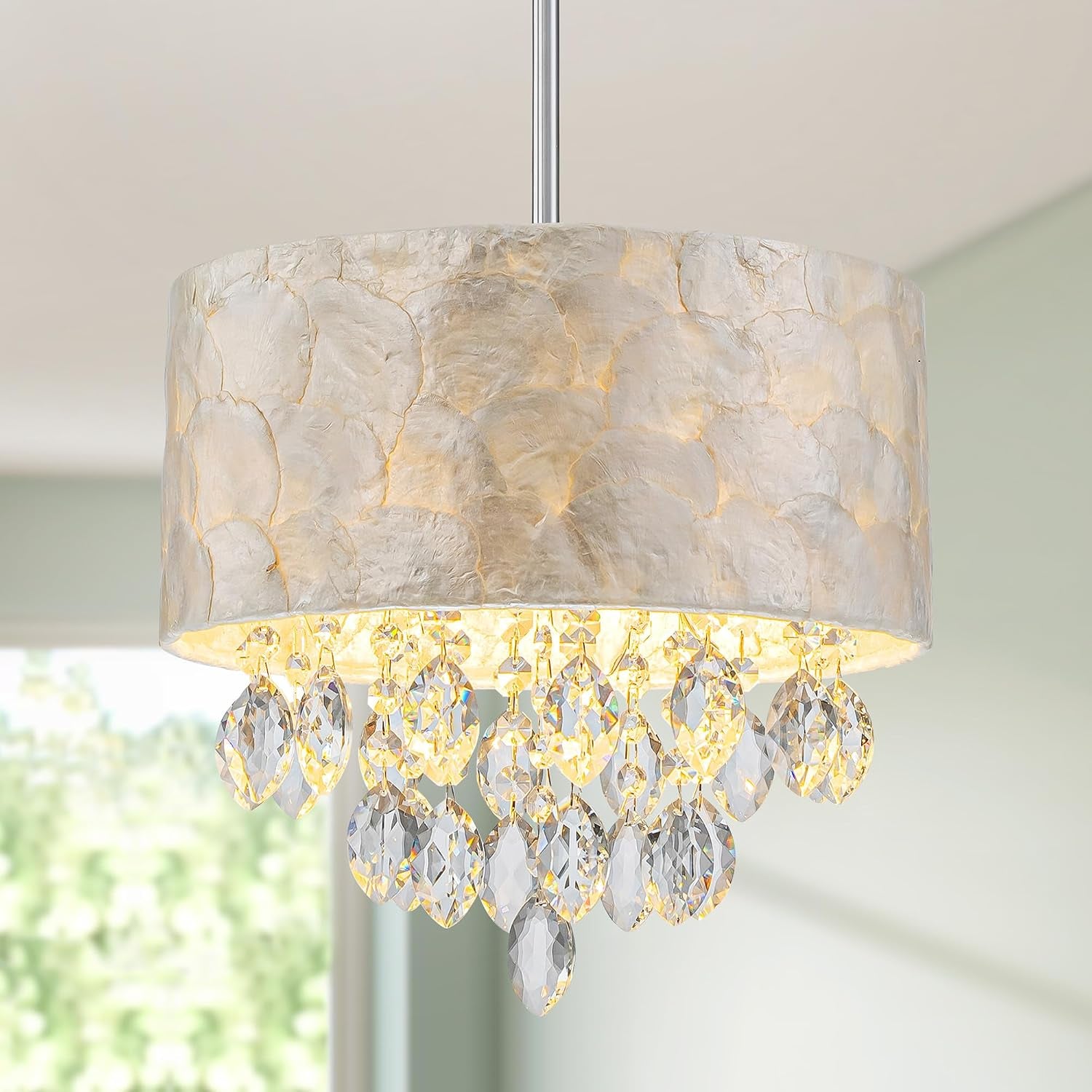Tight view of the textured shell drum shade with clear crystal teardrops and a silver downrod.