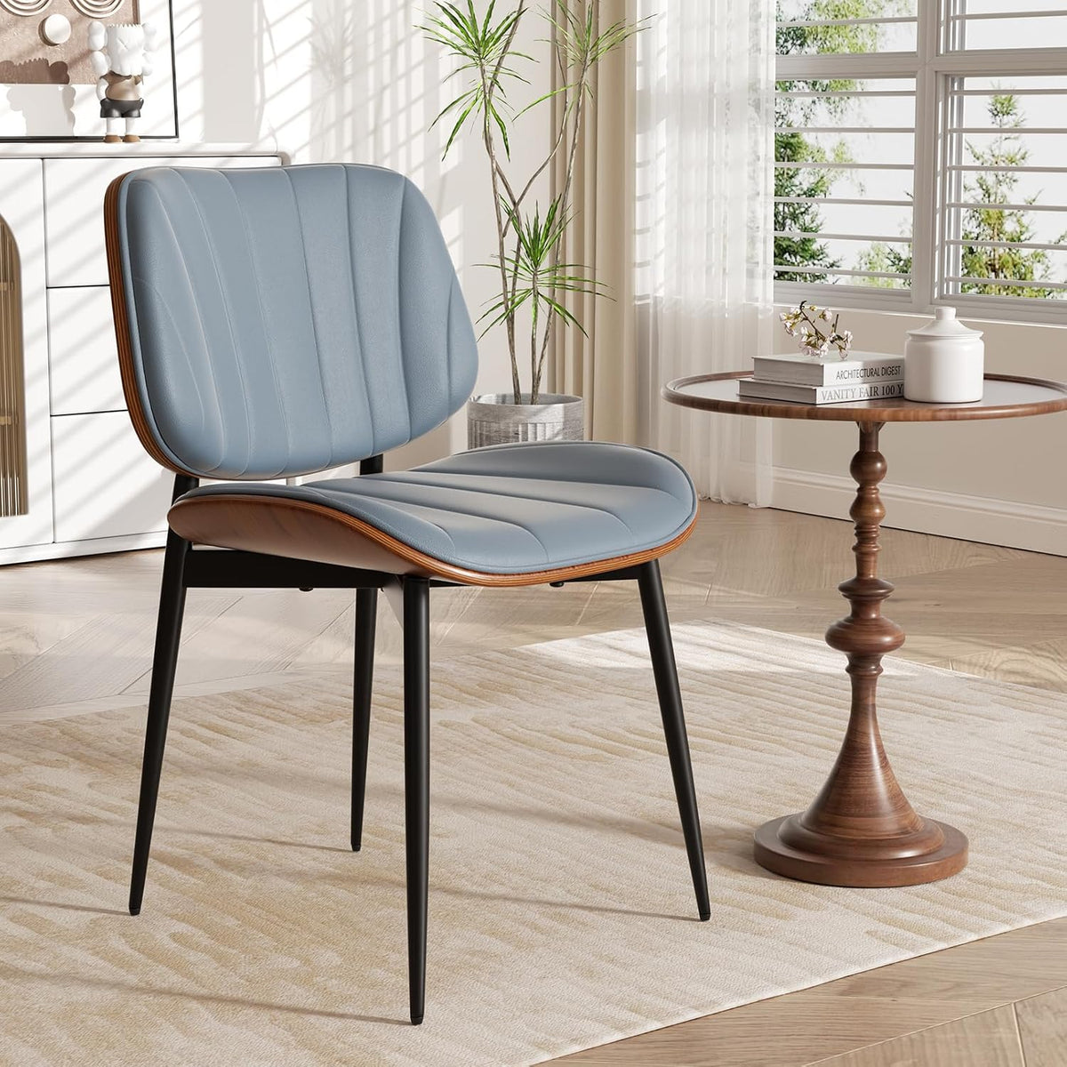 Single blue faux-leather dining chair with walnut bentwood back and black metal legs beside a small wood pedestal table.