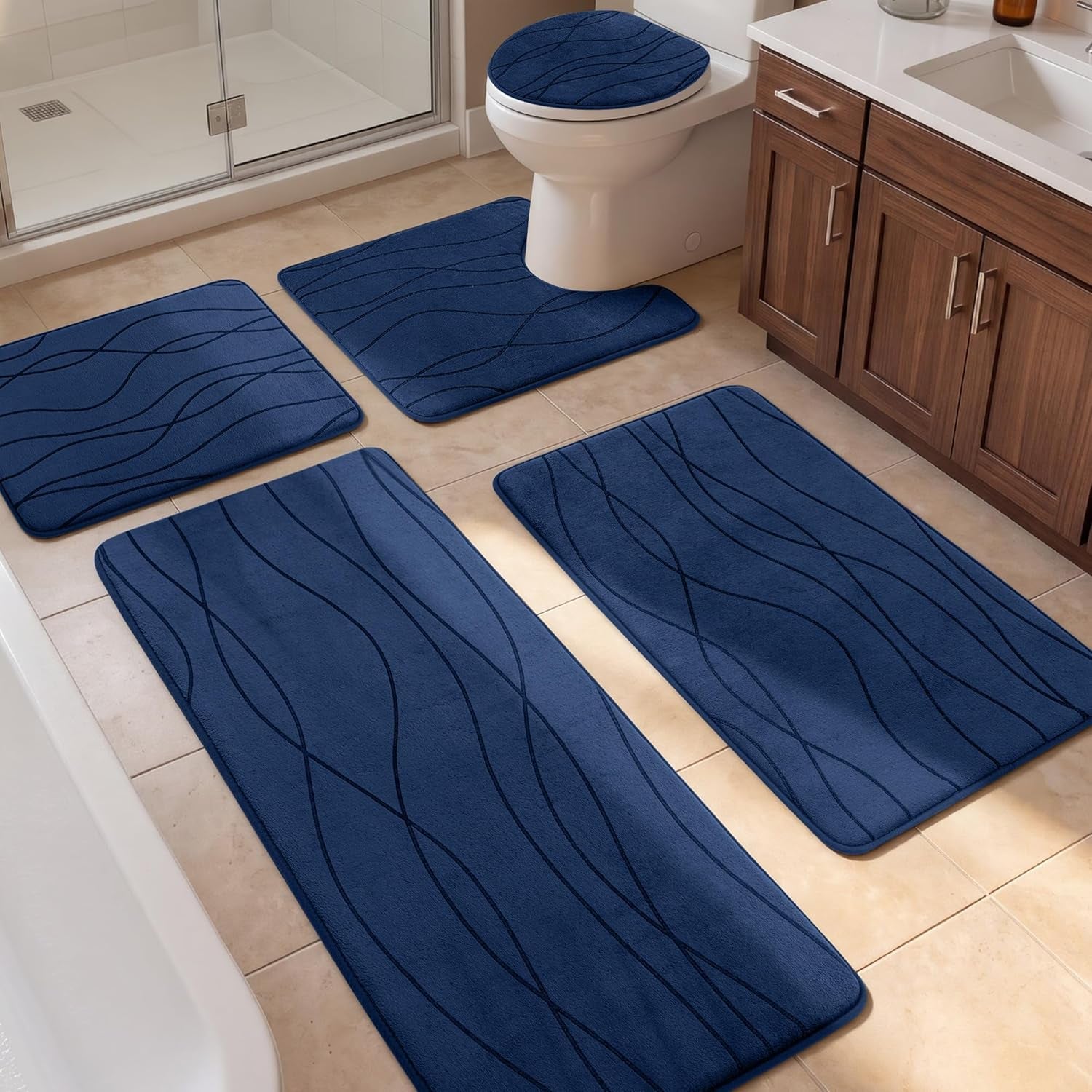 Bathroom scene with five navy blue mats arranged around tub, toilet and vanity