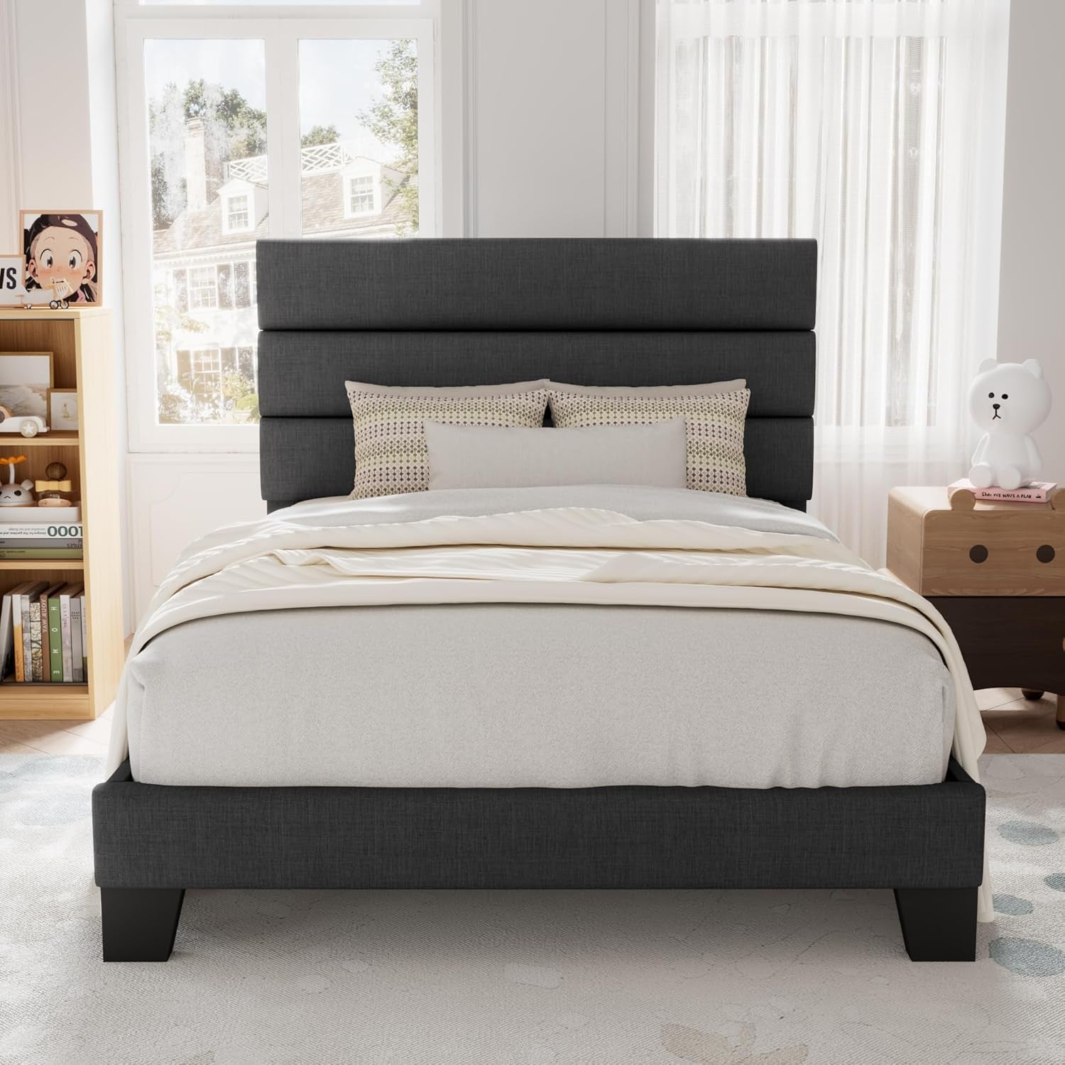 Front view of a dark gray fabric bed with a three-panel headboard in a child-focused room.