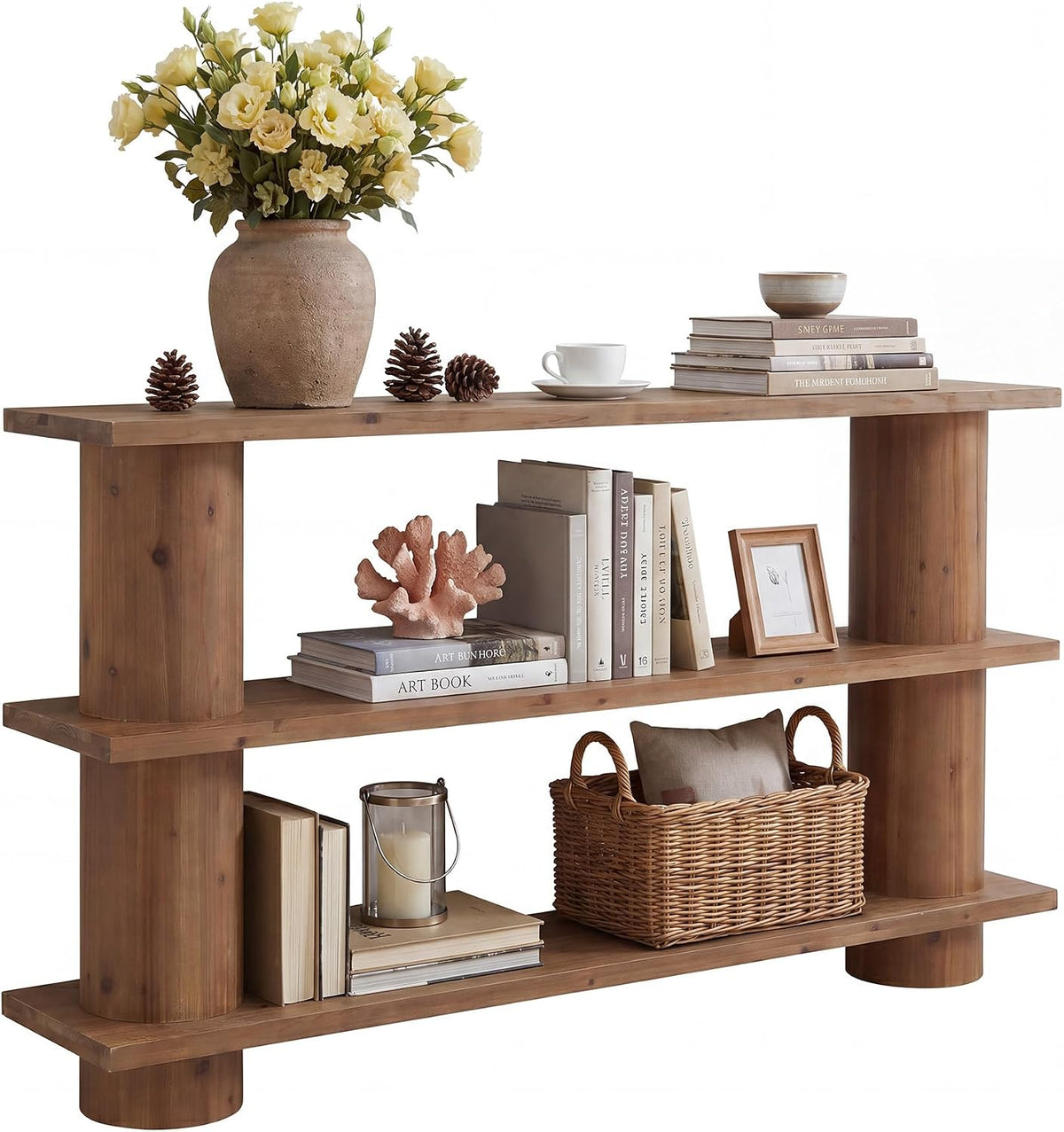 Three-tier wooden console shown from center, decorated with books, coral accent and a woven basket on lower shelf.