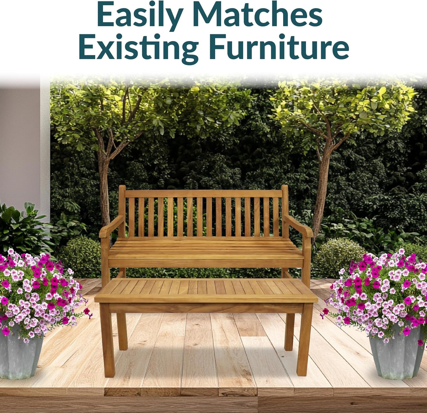 Teak coffee table placed in front of a wooden bench on a deck flanked by flowering potted plants