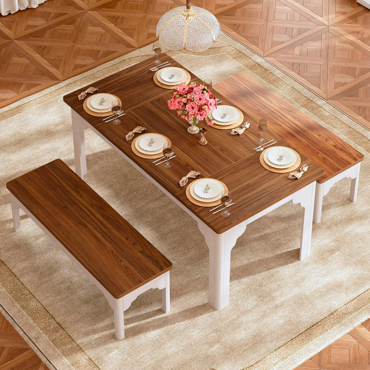 Top-down view of the brown wood tabletop set with plates and a bench visible in the foreground.