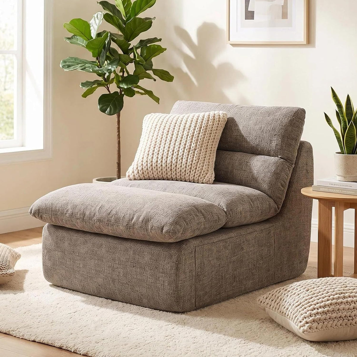 Single low-profile boneless floor chair in a taupe chenille-like fabric on a rug, with knit pillow and side table