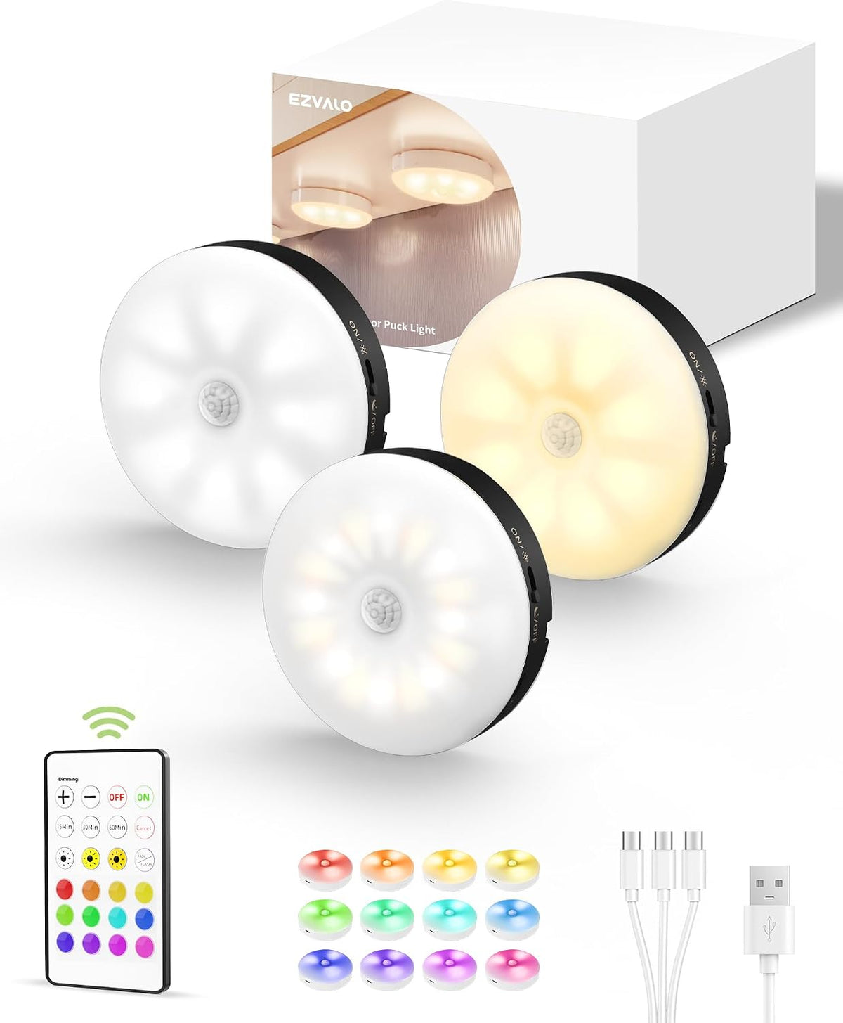 Three puck lights arranged near the retail box with the remote, multiple color swatches and USB charging cables laid out