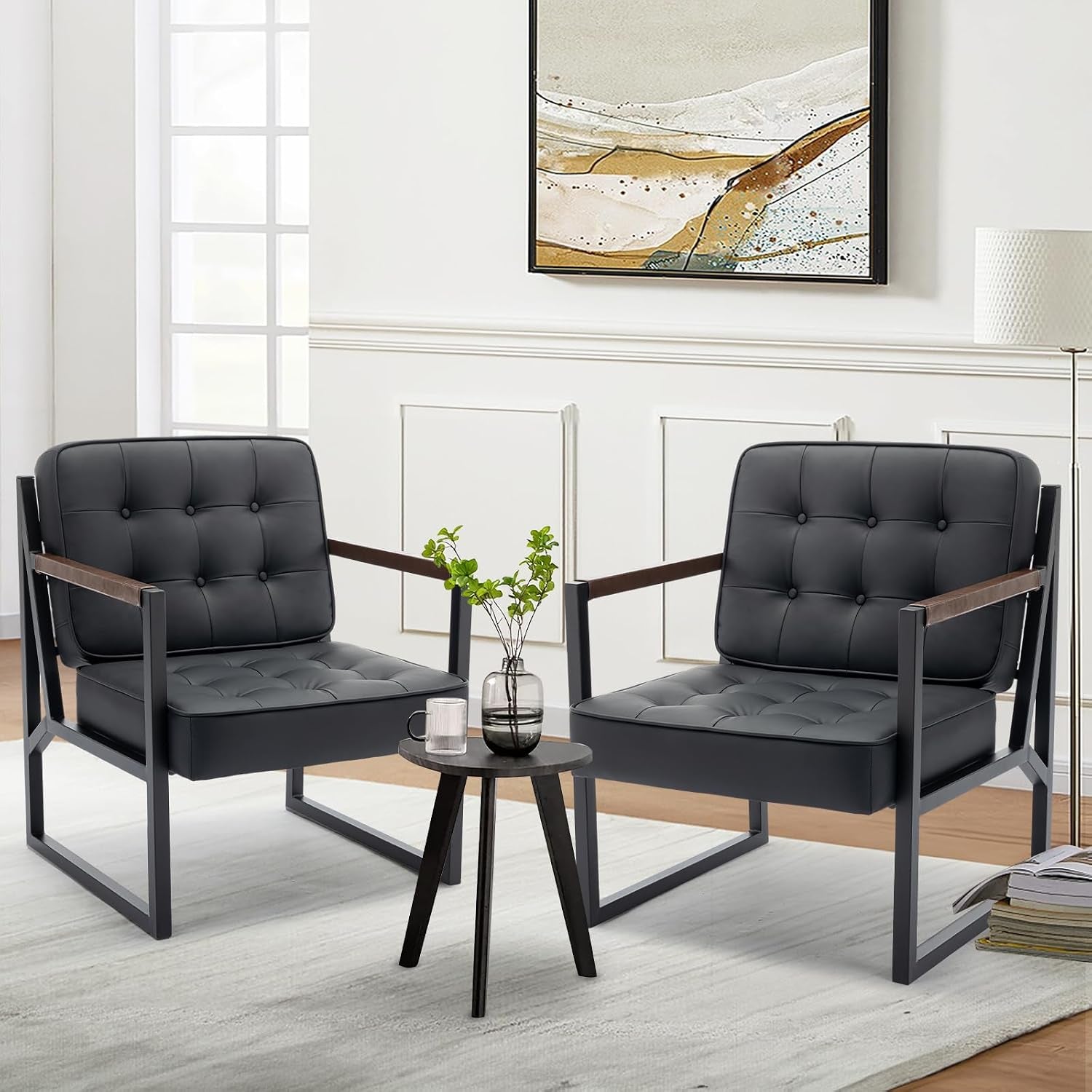 Pair of black tufted faux leather accent chairs with metal frames arranged in a neutral living room scene