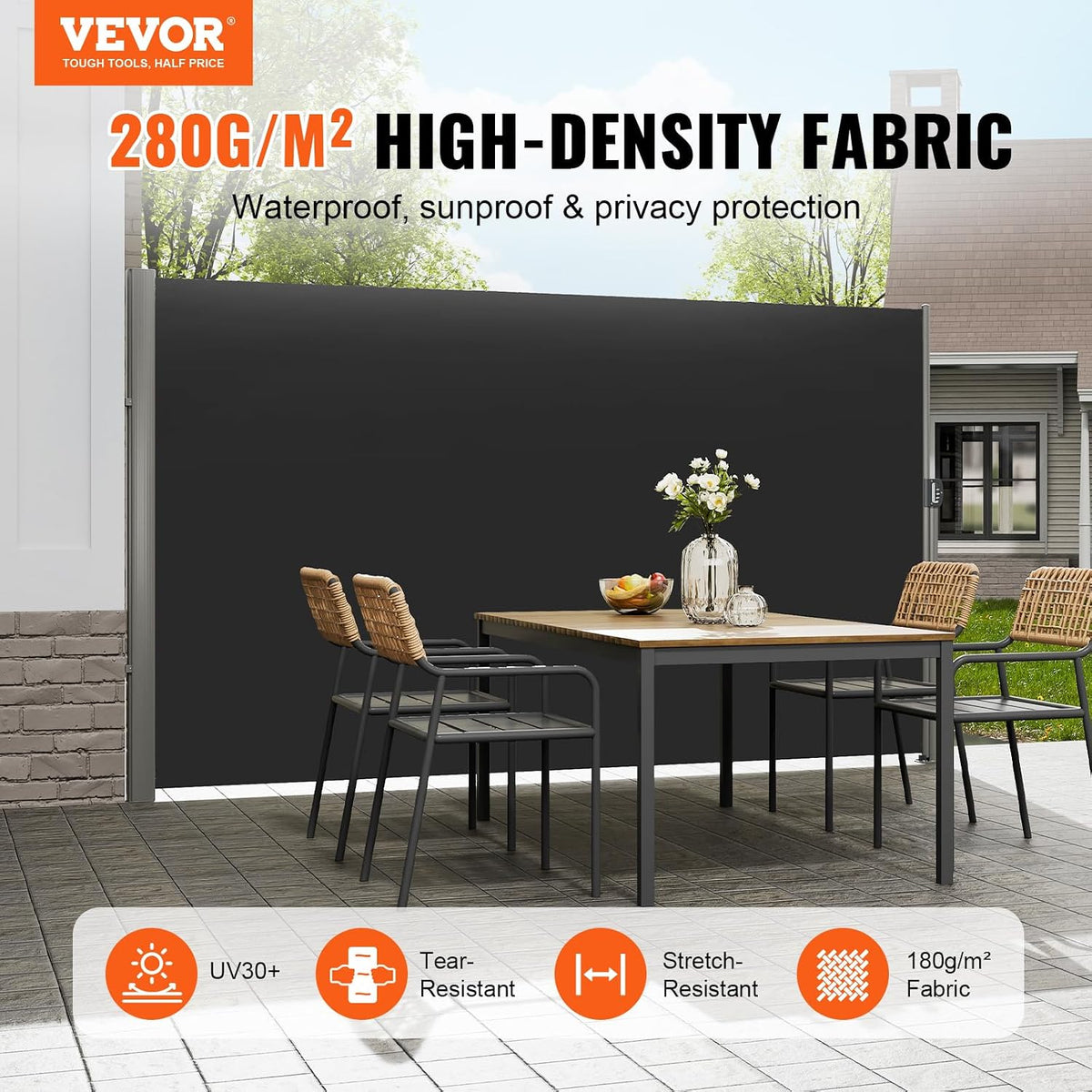 Black side awning installed on a patio behind a dining table, full-width front view showing the extended screen