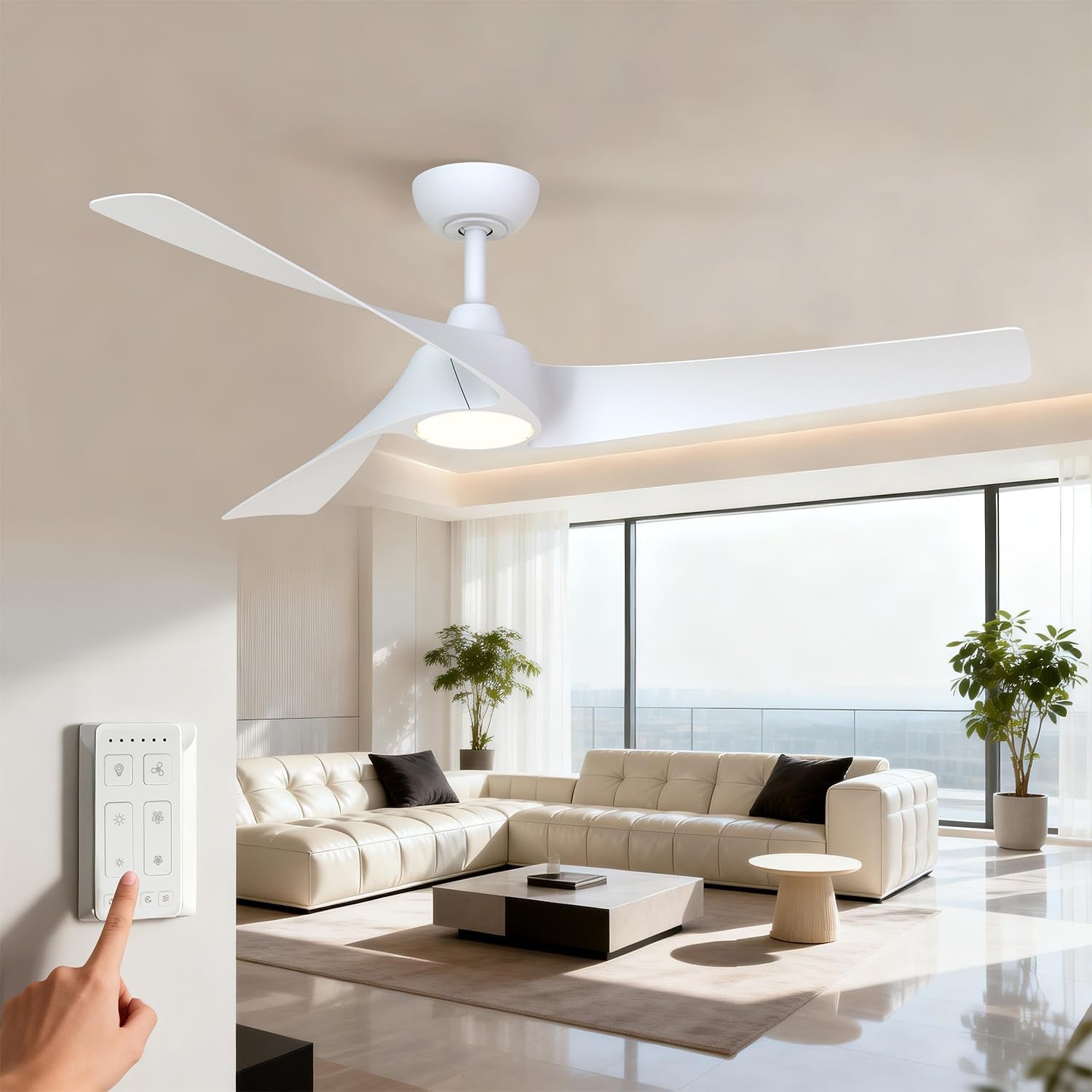 Bright living room with a white three-blade ceiling fan and a hand pressing the wall-mounted remote control.