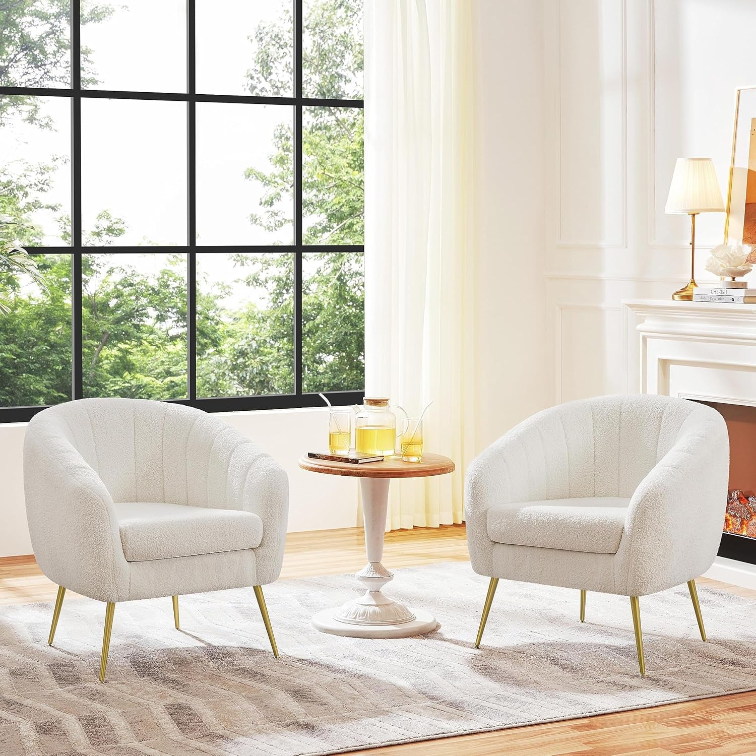 Two ivory bouclé barrel accent chairs flanking a small round table in a living room