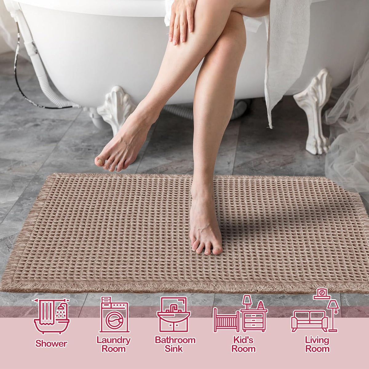 Taupe waffle bath mat in front of a bathtub on a dark tiled floor