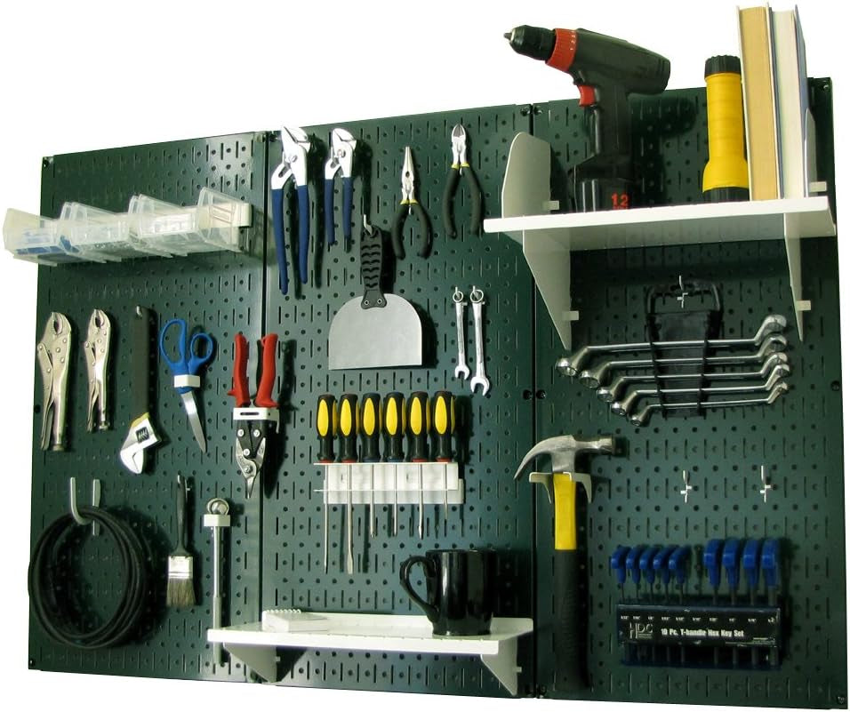 Dark green pegboard with white shelves, small clear bins and multiple tools hung for storage