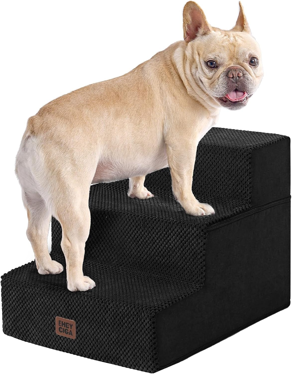 Light tan French bulldog standing on three-step black fabric pet stairs against white background