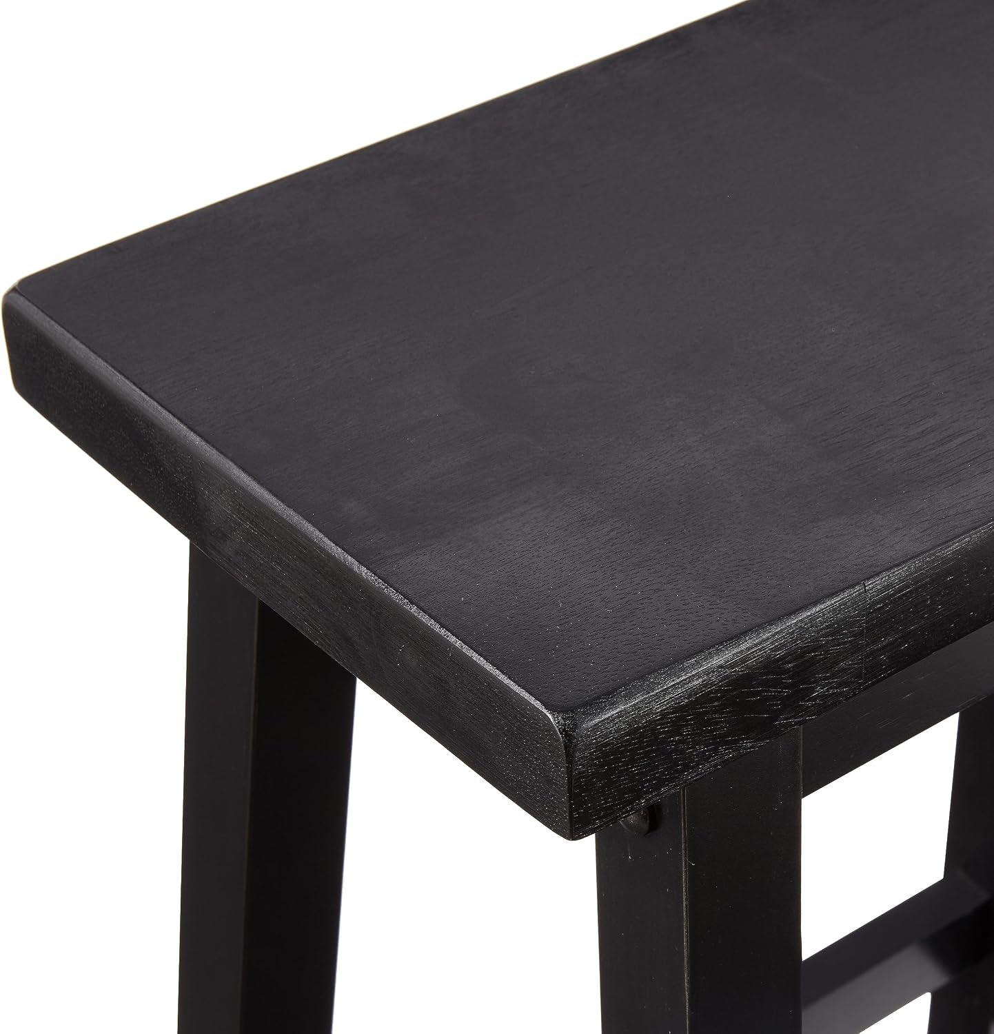 Close-up of black saddle-style wooden seat showing the contoured top and finished edge